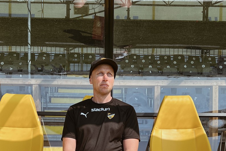 Petri Harainen istuu vaihtopenkillä ja katsoo ylöspäin.